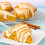 Pumpkin scones with glaze and drizzle on rustic table