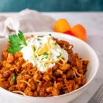 Slow Cooker Chili Mac in a bowl with melted cheese
