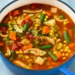 Chicken vegetable soup served warm in a rustic bowl