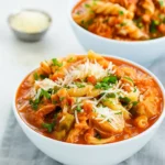 Crockpot Chicken Parmesan Soup in a rustic bowl with basil and Parmesan