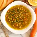 Greek Chickpea Soup in rustic bowl with parsley and lemon