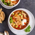 Healthy Chicken Tortilla Soup in rustic bowl with garnishes