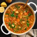 hearty vegan lentil soup in pot with veggies