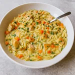 Creamy Chicken Pot Pie Orzo in a bowl with vegetables and chicken
