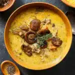 Wild rice and mushroom soup with crusty bread in rustic kitchen