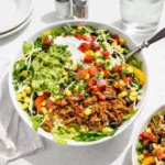carnitas burrito bowl filled with pork, rice, and toppings