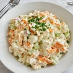 Creamy seafood salad with imitation crab in a white bowl with dill garnish