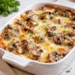 A bubbling Baked Cheesy Mushrooms Casserole with a golden breadcrumb crust.
