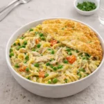 A steaming bowl of the Best Chicken Pot Pie Noodles with creamy sauce and vegetables.