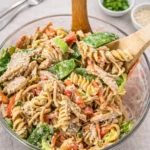 A large bowl of Chinese Chicken Pasta Salad with creamy dressing and sesame seeds.