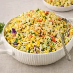 A large bowl of creamy Coleslaw Pasta Salad on a wooden table.