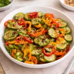 A bowl of viral Cucumber Sweet Pepper Salad with chili crunch and ginger dressing.