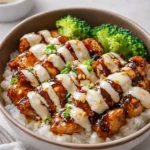 A delicious bowl of Sticky Chicken Rice Bowls with honey glaze and vegetables.