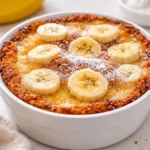 The Best Southern Banana Cobbler Dessert topped with melting vanilla ice cream in a baking dish.