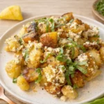 Crispy Baked Feta Potatoes in a rustic dish with basil