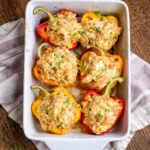A tray of colorful Creamy Chicken Stuffed Peppers topped with melted cheese.