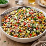 A colorful Dense Bean Salad with chickpeas and feta in a ceramic bowl.