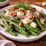 Fresh Green Bean and Feta Salad in a white bowl on a wooden table.