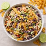A large bowl of Frito Cowboy Cabbage Salad topped with Chili Cheese Fritos.