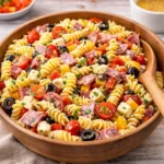 A vibrant bowl of Italian Pasta Salad on a wooden table.